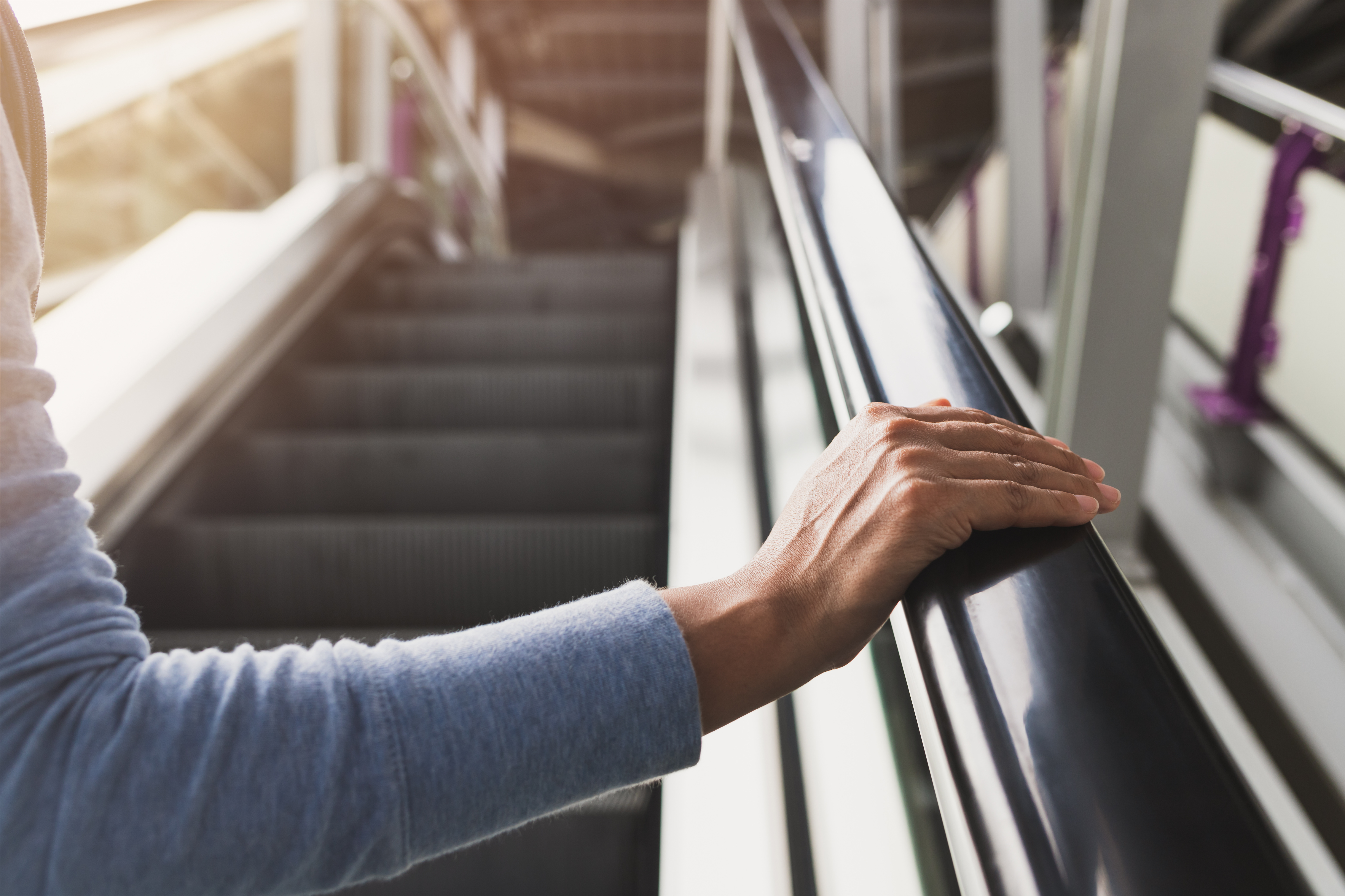 Woman's right hand on the escalator handrail